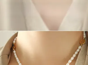 Detail der Süßwasserperlenkette mit goldenem Fu-Anhänger am Hals des Modells