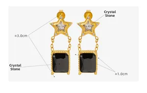 Détail de boucles d'oreilles étoile dorées avec cristal clair et pendentif noir
