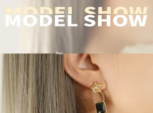 Vue détaillée de la boucle d'oreille étoile dorée avec pendentif cristal noir rectangle
