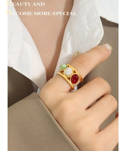 Detail of vintage gold wide ring with green, white, and red oval gemstone inlays