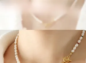 Détail du collier de perles baroques avec accents rouges et fermoir à bascule doré