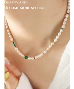 Détail d'un collier de perles d'eau douce avec agate verte et fermoir à bascule doré