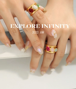 Close-up of vintage wide rings with oval glass stones in gold finish on fingers
