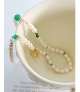 Gros plan détaillé d'un collier de perles avec des perles d'agate verte et fermoir OT