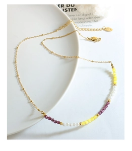 Détail du collier choker avec perles œil-de-chat jaunes et violettes et fermoir doré