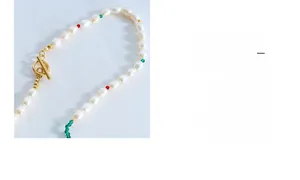 Détail du collier de perles d'eau douce avec perles rouges et vertes et fermoir OT doré