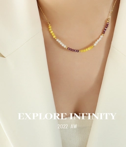 Détail du collier choker avec œil de chat jaune et perles porté par le mannequin