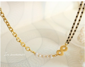 Detail of geometric necklace with pearls, infinity symbol and mixed chain links