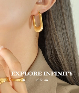 Gros plan de boucles d'oreilles dorées en U et de bagues assorties sur un mannequin