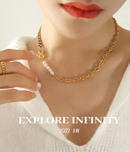 Close-up of a gold chain necklace with infinity symbol, pearls and matching ring