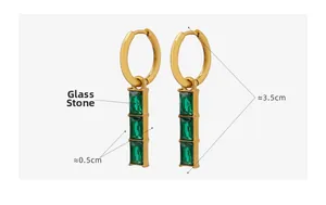 Detail of gold titanium earrings with triple stacked green glass stones in art deco style