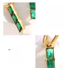 Detail view of 18K gold-plated titanium steel earrings with emerald green rectangle stones