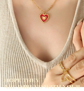 Detail of red enamel heart pendant necklace and double-ring with diamond accents