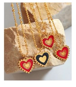 Detailed view of double-sided red and black heart pendants on gold ball chains