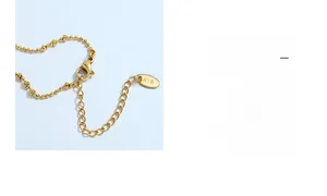 Detail of gold-plated bead chain with lobster clasp and K18 engraved metal tag