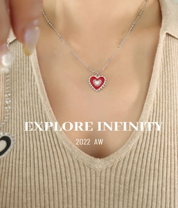 Detail of silver bead chain and red heart pendant with solar texture on a model