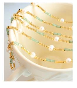 Détail du collier de perles d'eau douce et aventurine verte avec fermoir OT sur tasse