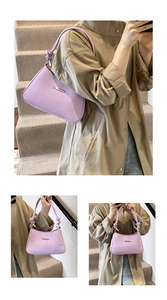 Detailed view of lilac chevron textured underarm bag with decorative knot and gold hardware