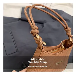 Detail view of woven brown handbag featuring dual rope straps and gold hardware accents