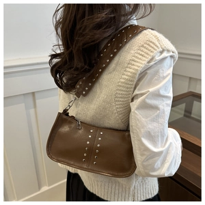 Détail du sac d'épaule en cuir PU marron café avec rivets argentés sur la bandoulière