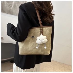 Dettaglio borsa tote in tela vintage con manico in pelle e ciondolo a nuvola