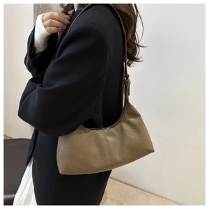 Detail of the vintage dark khaki pleated underarm bag with textured faux leather finish