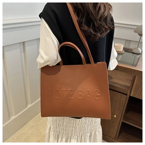 Brown leather tote bag featuring a minimalist design with an embossed logo for daily style