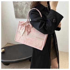 Detail der rosa Blumentasche mit gemustertem Schal und Fashion Bag Text am Griff