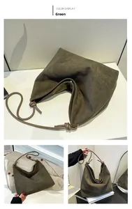Detail of dark green suede hobo bag featuring a knotted handle and large capacity