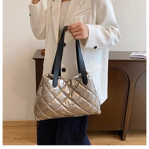Detail of metallic gold quilted tote bag showing high-gloss texture and stitching