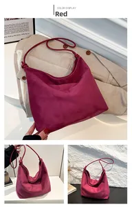 Detail of red suede hobo bag with side knot accents and a minimalist design