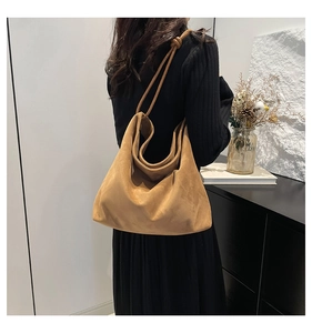 Macro detail of brown faux suede tote bag featuring a minimalist knotted shoulder strap