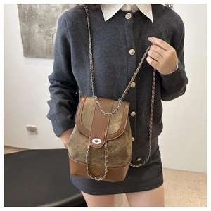 Detailed close-up of a vintage khaki canvas and brown leather patchwork chain bag