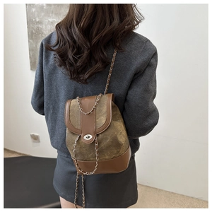 Detail view of a vintage brown patchwork chain bag worn as a crossbody shoulder bag