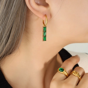 Gold-plated hoop earrings with vertical green crystal drops and matching rings