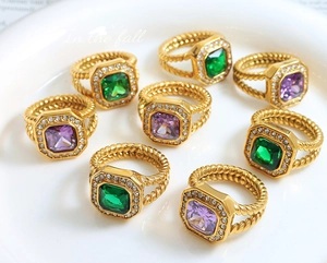 Detailansicht eines Vintage-Rings mit smaragdgrünem Stein und goldener Kordel-Ringband