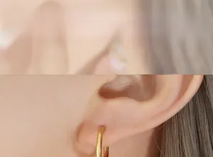 Close-up of minimalist golden hoop earrings with satin finish shown on a model