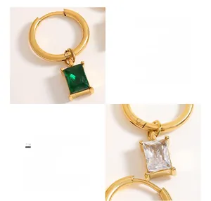 Detail of 18K gold plated titanium earrings with emerald green and clear zircon pendants