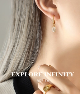 Detail of gold-plated hoop earrings with rectangular zircon and matching buckle ring