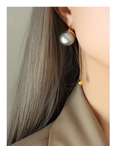 Détail de la boucle d'oreille pendante avec perle gris argent et chaîne dorée