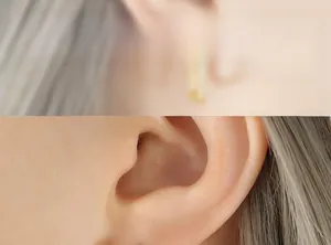 Dettaglio di eleganti orecchini geometrici placcati in oro con intarsio di zircone