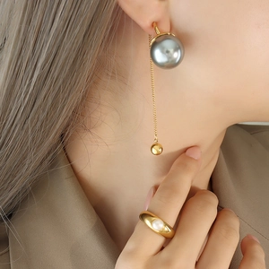 Parure de bijoux minimaliste avec boucles d'oreilles dorées et bague perle sur mannequin