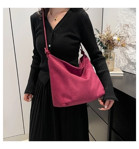 Close-up of knotted shoulder strap on a magenta suede hobo tote bag for women