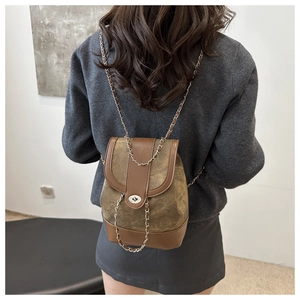 Detail of vintage patchwork mini backpack with chain strap and metal swivel lock