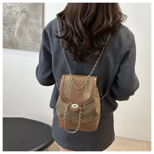 Model wearing a vintage brown patchwork mini backpack with stylish metal chain straps
