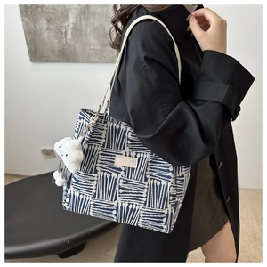 Detailed view of tote bag with blue geometric pattern and white cloud plush charm