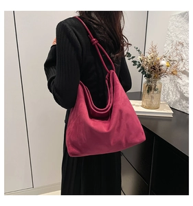 Deep pink large suede tote bag worn by a model in a minimalist urban setting