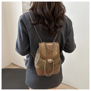 Close-up of vintage chain strap and retro color-block patchwork on leather backpack