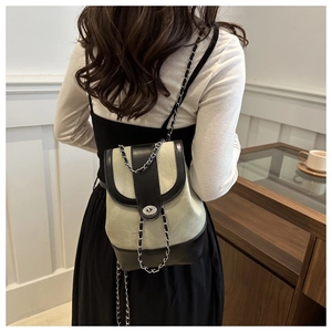 Detail of a green suede and black leather patchwork backpack with chain strap and metal lock
