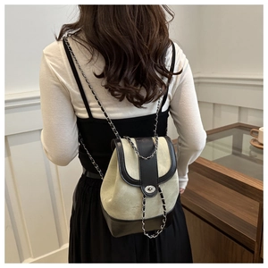 Detail of trendy patchwork chain backpack with silver twist lock and mixed textures